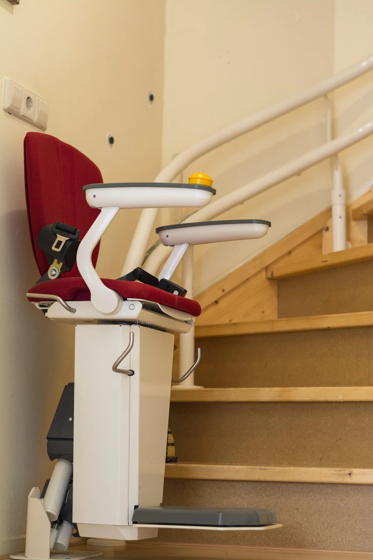 Treppenlift mit rotem Sitz an einer Treppe