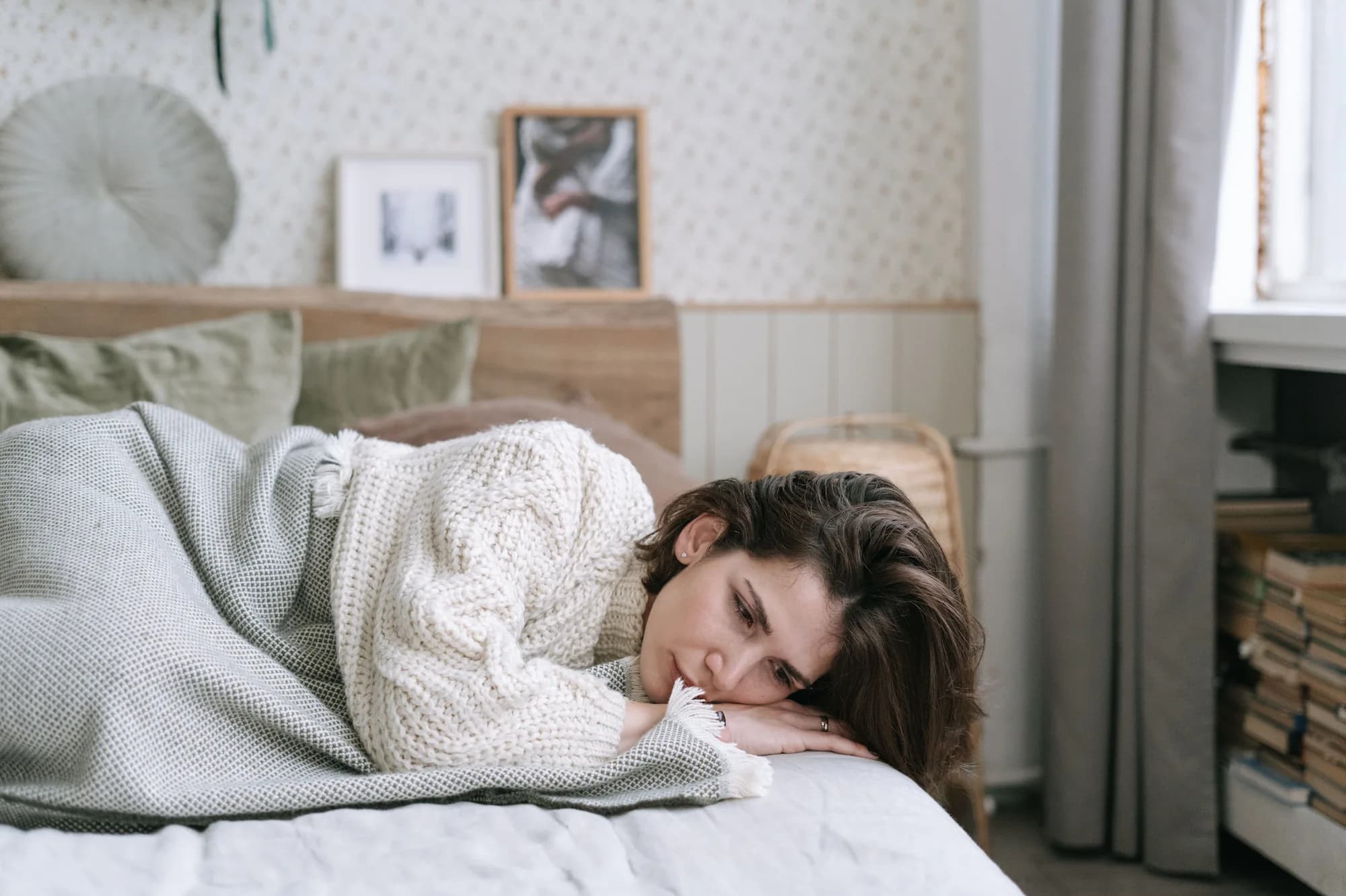 Eine Frau liegt wach unter einer Decke im Bett