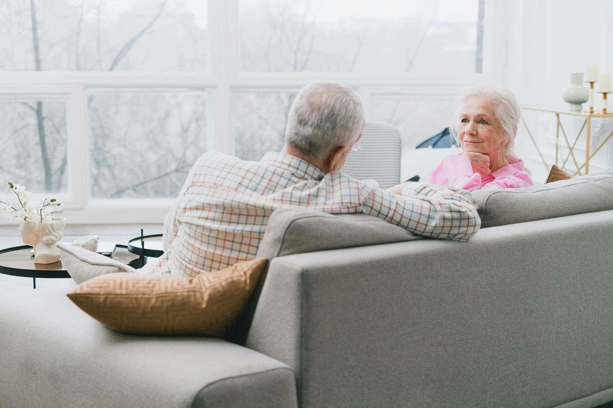 Ein älteres Paar im Gespräch auf dem Sofa