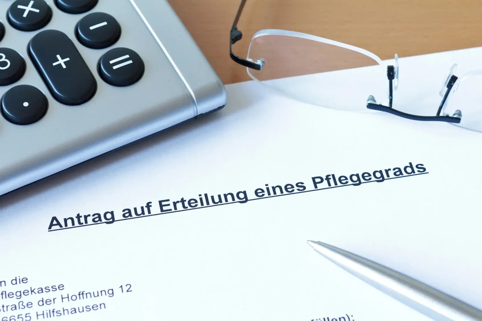 Antrag zur Feststellung eines Pflegegrads mit Brille und Taschenrechner