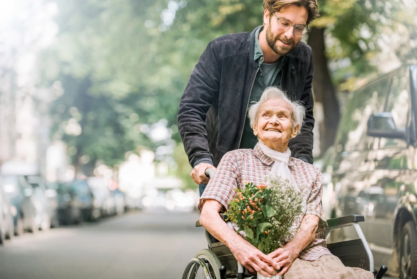 Eine Frau im Rollstuhl und ihr Begleiter im Freien