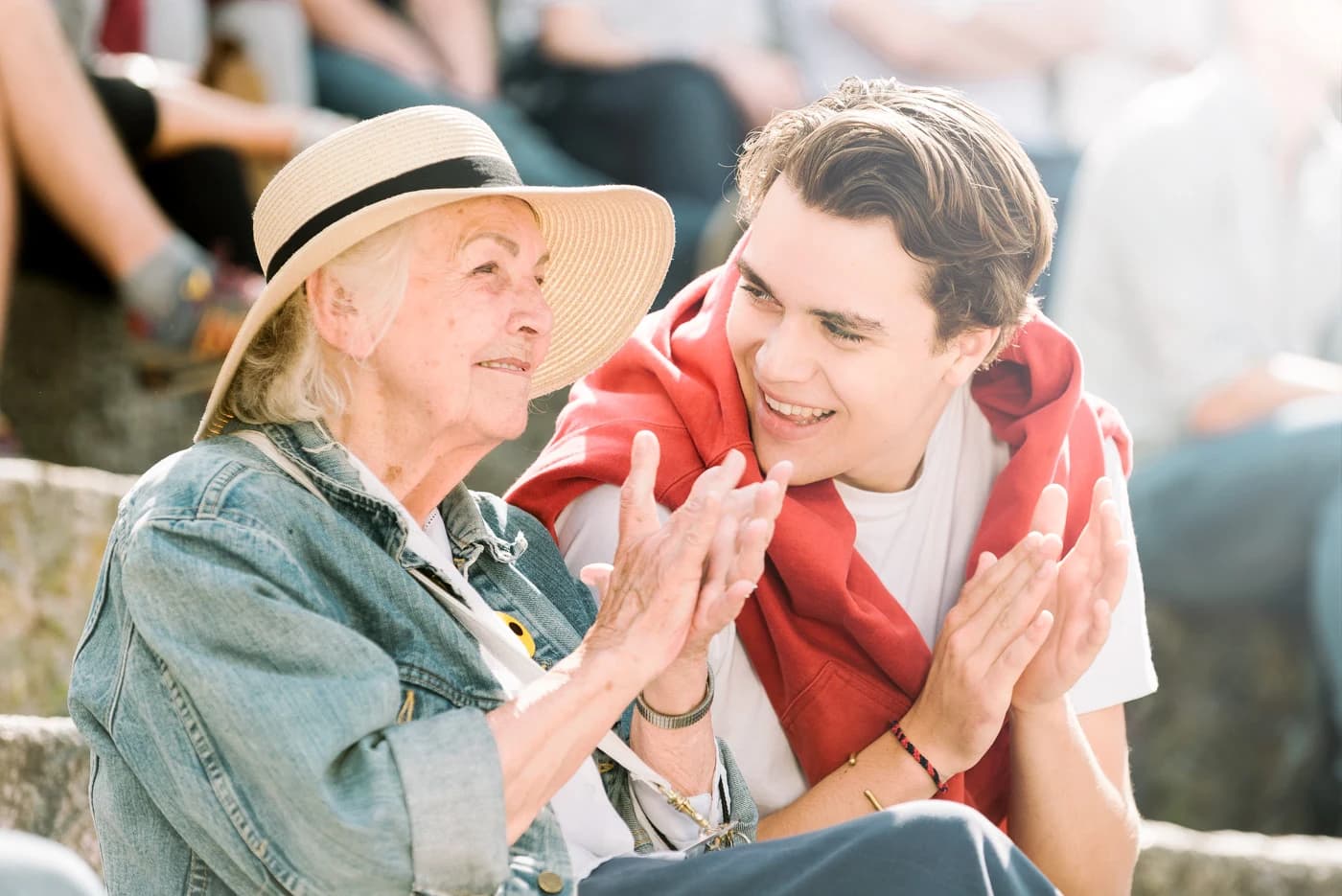 Eine Seniorin und ihr Alltagsbegleiter lachen gemeinsam im Freien